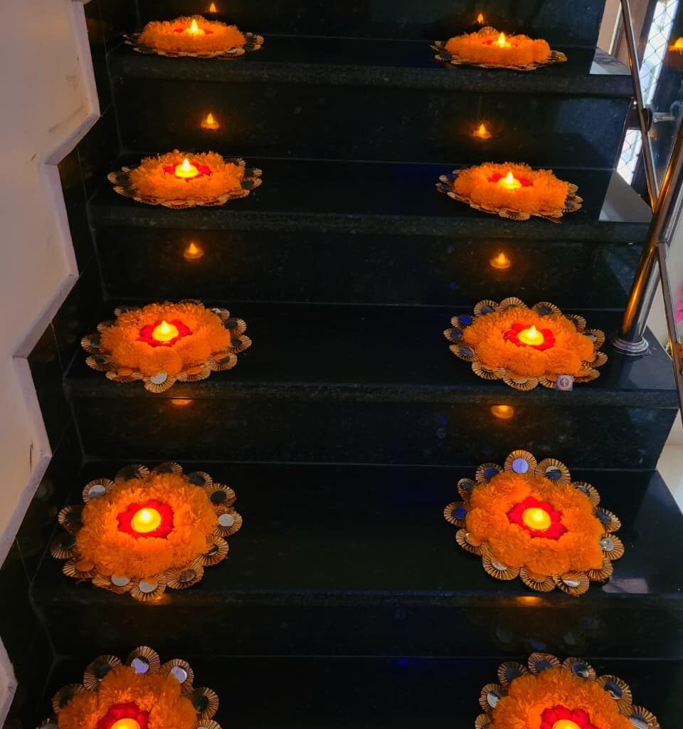 Floral mats with diyas on the stairs – Kachi Rasoi